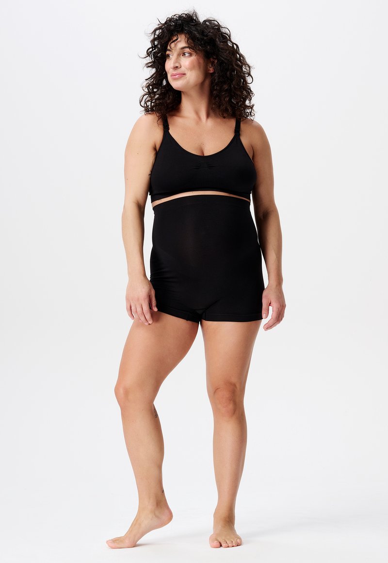 Svart sömlös bralette och set med högmidjade shorts. Mjukt tyg, breda remmar och en åtsittande design med slät yta. Inga mönster eller detaljer.