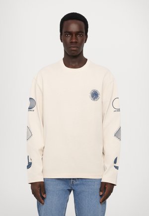 Beige lange mouwen T-shirt van katoen met blauwe grafische ontwerpen op de borst en mouwen, met een ronde halslijn en een relaxte pasvorm.