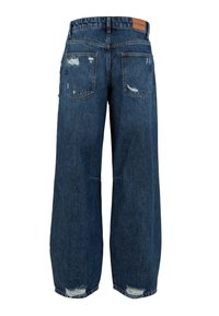 Jean en denim bleu à jambes larges avec des détails usés sur les poches et les ourlets, comprenant des poches arrière et un patch en cuir de la marque sur la ceinture.