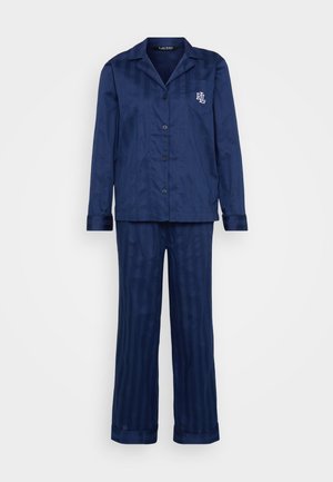 Navy modri pižama set iz gladkega materiala, ki vključuje srajco s gumbi in žepom ter ustrezne prugaste hlače z manšetami.