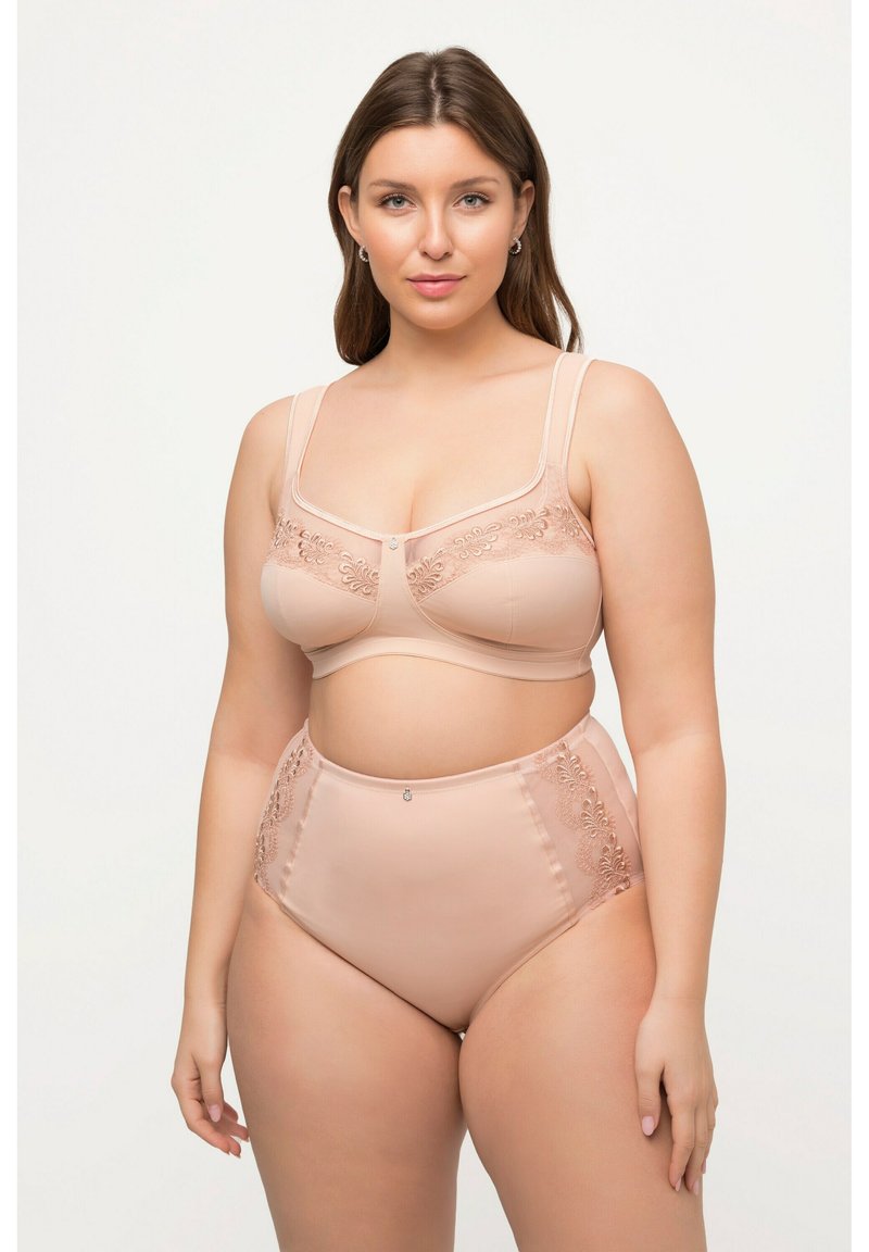 Ensemble de lingerie beige comprenant un bralette avec des détails brodés et des culottes taille haute avec des accents en dentelle. Texture lisse et satiné.