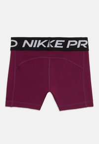 Burgunderfargede Nike Pro kompresjonsshorts med synlige sømmer og et svart livbånd med "NIKE PRO" i store hvite bokstaver.