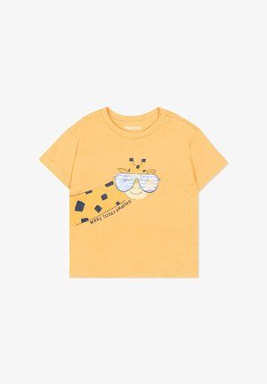 Maglietta gialla a maniche corte per bambino con una giraffa sorridente che indossa occhiali da sole specchiati e la scritta "RENDI OGGI STRAORDINARIO" sul davanti.