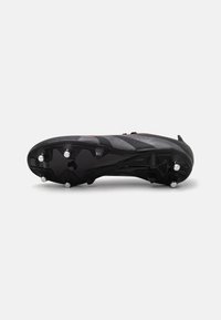 Botín de fútbol negro con una parte superior texturizada, rayas horizontales y seis tacos de metal para tracción en la suela. Diseño ligero y ergonómico.