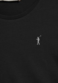 Zwarte katoenen t-shirt met een kleine witte geborduurde figuur die een gereedschap vasthoudt, ronde halslijn en een zachte textuur.