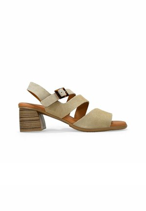 Sandalia de tacón de ante beige con tres correas cruzadas, hebilla ajustable y tacón de bloque de madera apilada. Diseño de punta abierta. Textura suave.