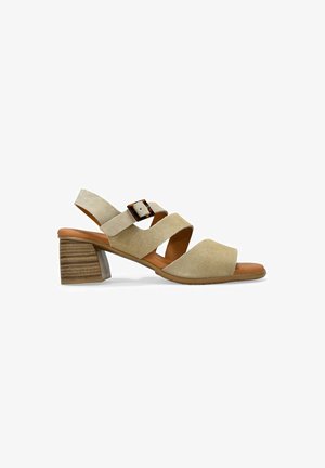 Sandalia de tacón de ante beige con tres correas cruzadas, hebilla ajustable y tacón de bloque de madera apilada. Diseño de punta abierta. Textura suave.