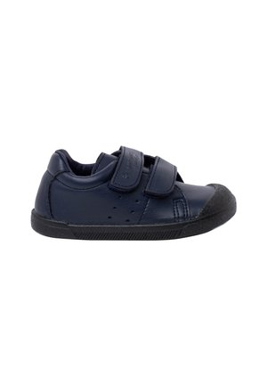 Zapatilla infantil en azul marino, confeccionada en cuero liso, con dos tiras de Velcro. Presenta una puntera de goma negra y una suela texturizada para un mejor agarre.
