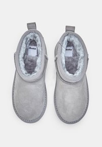 Sive antilopne čizme do gležnjeva s mekim sivim krznom i šivenim detaljima. Imaju trakice za lakše obuvanje. Logotip brenda vidljiv unutar čizama.