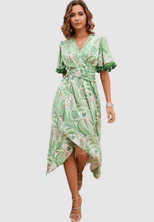Vestido verde con estampado de paisley, con mangas cortas, diseño envolvente y un dobladillo asimétrico. Presenta detalles de pompones en las mangas. Tejido suave.