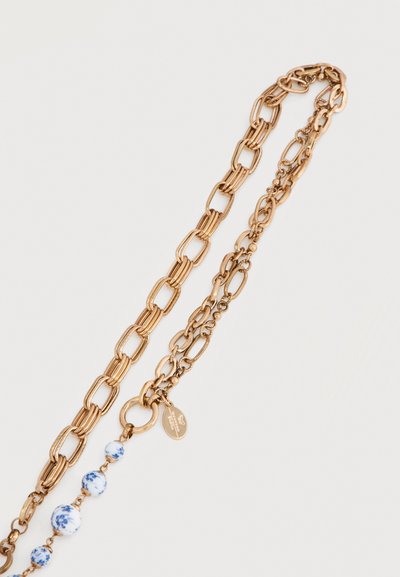 Κολιέ αλυσίδας με χρυσό τόνο, με ποικιλία στυλ συνδέσμων και λευκές κεραμικές χάντρες διακοσμημένες με μπλε λουλουδάτα σχέδια.