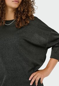 Sort, glitrende oversized top med trekvartærmer og rund udskæring, der har et subtilt tekstureret stof og en afslappet pasform.