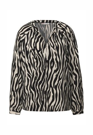 Blusa a rayas de cebra en blanco y negro con escote en V, mangas largas y detalles fruncidos en los puños. Hecha de tela ligera.