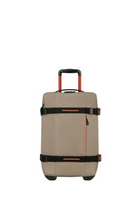 Maleta beige de material blando con acentos naranjas, mango retráctil, dos correas negras, un bolsillo delantero con cremallera y ruedas negras.