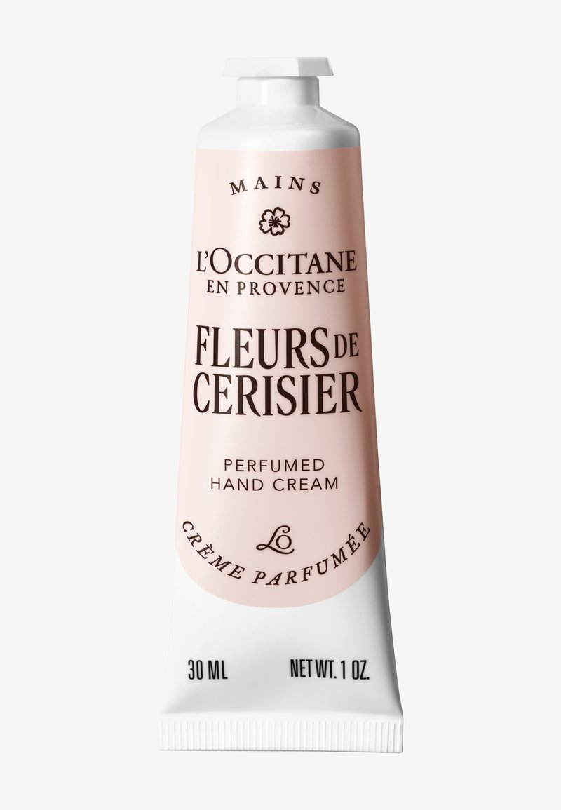 L'Occitane Fleurs de Cerisier handkräm i ett mjukt rosa metallrör, med svart text och ett vitt lock, märkt för 30 ml parfumerad kräm.