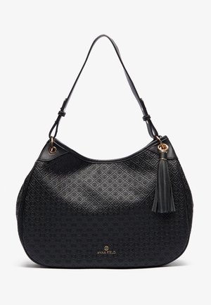 Schwarze gepunktete Lederhandtasche mit verstellbarem Schultergurt, goldenen Akzenten und einem dekorativen Quasten, versehen mit dem Anna Field Logo.