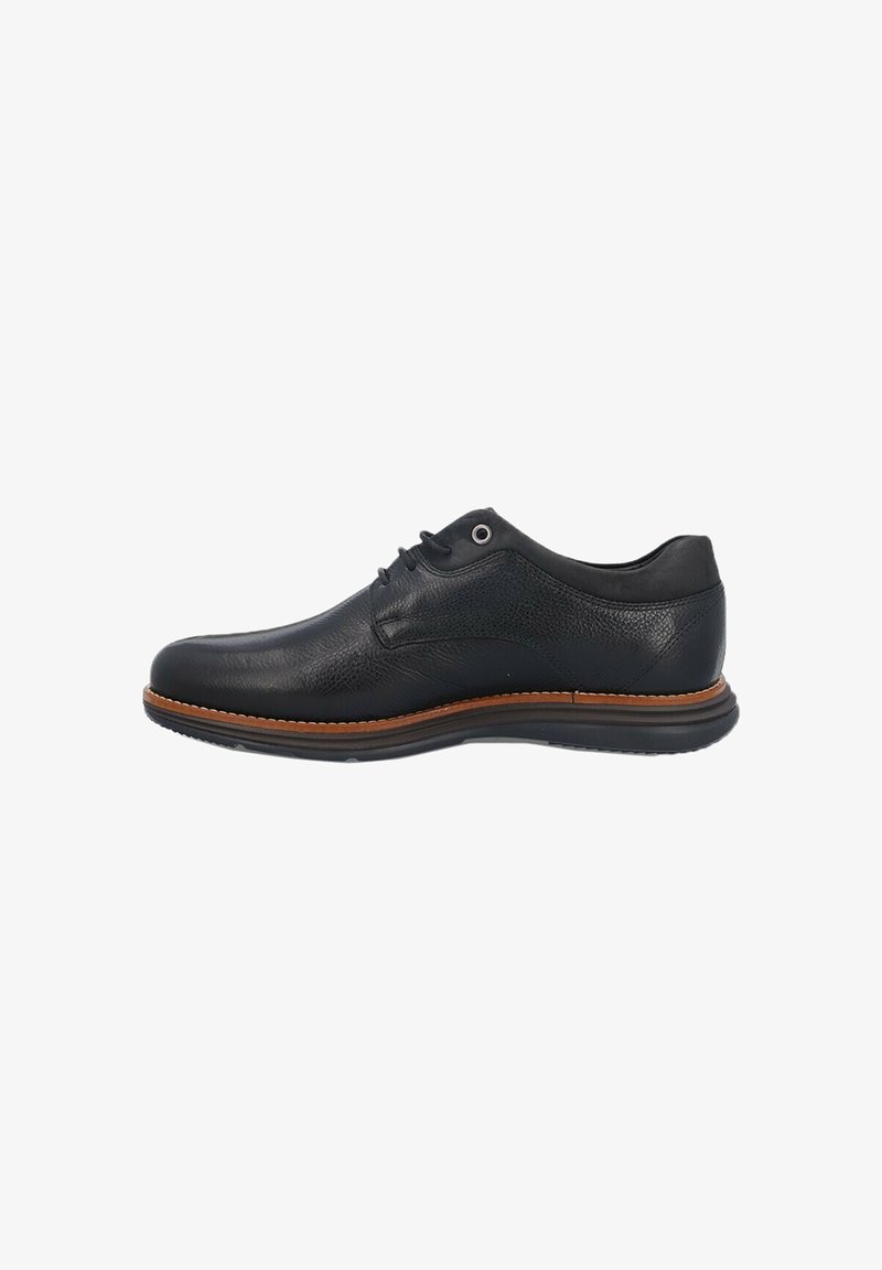 Zapato de cuero negro con un acabado texturizado, punta redondeada y suela marrón en contraste. Presenta cierre de cordones y un diseño minimalista.