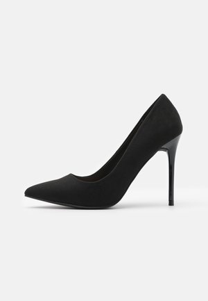 Schwarzer High-Heel-Pumps aus Wildleder. Mit spitzer Zehenpartie und einem eleganten, glänzenden Stilettoabsatz. Glatte Textur und minimalistisches Design.