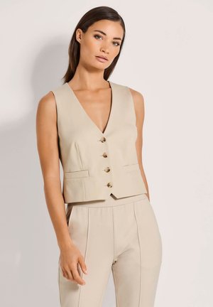 Beige mouwloos vest met een diepe V-hals, vijf gouden knopen en twee voorzakken. Gladde stof met een getailleerd ontwerp.