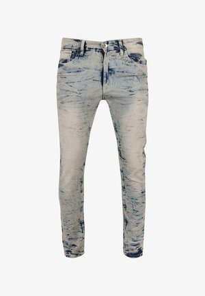 Vyblednuté modré rifľové nohavice s úzkym strihom, ktoré majú zničenú textúru a jemné vzory. Dizajn s piatimi vreckami a štandardným gombíkovým uzáverom.