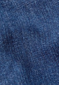 Jeans υλικό σε σκούρο μπλε, με υφή και υπολογισμένες παραλλαγές χρώματος. Λείο επιφάνεια με ελαφριά �γυαλάδα.