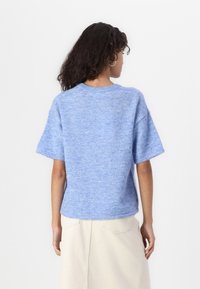 Sweater curto de manga curta azul claro com um design texturizado. Apresenta um decote redondo e um corte descontraído, feito de um material tricotado suave.