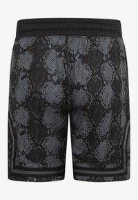 Svarte og grå shorts med mønster av slanger, elastisk midjebånd og kontrasterende sideaksenter. Teksturert overflate gir visuell dybde.