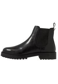 Schwarze Leder-Chelsea-Stiefel mit elastischen Seitenpanelen, runder Zehenpartie und profilierten Gummisohlen für besseren Halt. Mit einer Zuglasche auf der Rückseite.