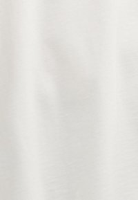 Valge puuvillane kangas, millel on sile tekstuur, mis peegeldab kergelt valgust. Pinna peal pole mustreid ega silmapaistvaid detaile.