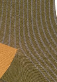 Strickgewebe-Socken in Olivgrün mit kontrastierendem gelben Zehenbereich. Besitzt horizontale strukturierte Streifen und verstärktes Fersendesign.