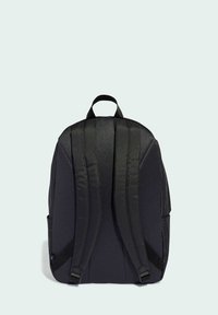Mochila negra con tejido texturizado, correas acolchadas, asa superior y bolsillos laterales, con un diseño elegante y moderno.