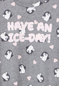 Un tessuto grigio presenta un motivo di pinguini dei cartoni animati e cuori rosa, con il testo "BUONA GIORNATA GHIACCIATA!" in lettere bianche e grassetto.