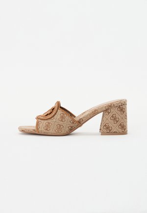 Sandal in beige con tacco a blocco e motivo decorativo, open toe e accentuazione del logo sulla parte superiore. Upper in tessuto testurizzato e suola liscia.