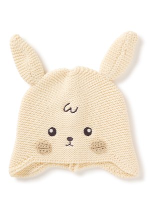 Gorro de bebé tejido de color crema con orejas de conejo, ojos bordados, nariz, mejillas y un pequeño remolino en la frente.