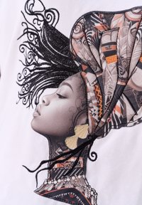 Geborduurd textiel met een profiel van een vrouw met ingewikkelde patronen in haar hoofddoek, zwarte en gouden accenten, geplaatst op een witte achtergrond.
