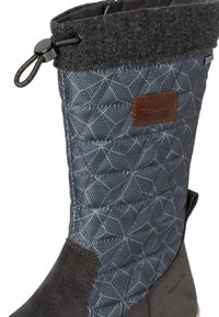 Botte imperméable grise avec un design matelassé, des accents en daim et un cordon ajustable en haut. Présente un tissu texturé et des coutures renforcées.