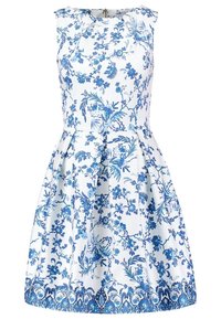Robe blanche sans manches avec des motifs floraux et botaniques bleus, taille cintrée, jupe plissée et fermeture éclair au dos.