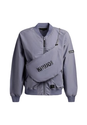 Helelillakaslilla bomberjakk lukuga ees ja sobiv rinnaesise kott, millel on silt "KHUJO 2001".