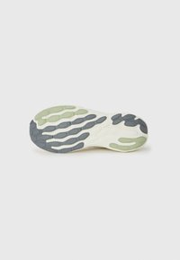 Shoe outsole with a wave-like design. Primarily cream, featuring accents in gray and light green. Flexible texture with patterned grip zones.