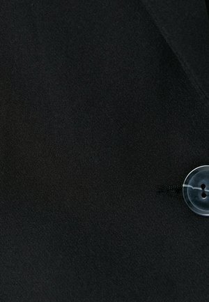 Tissu noir avec une texture lisse, présentant un bouton transparent. Un design ajusté avec un léger éclat et une silhouette classique.