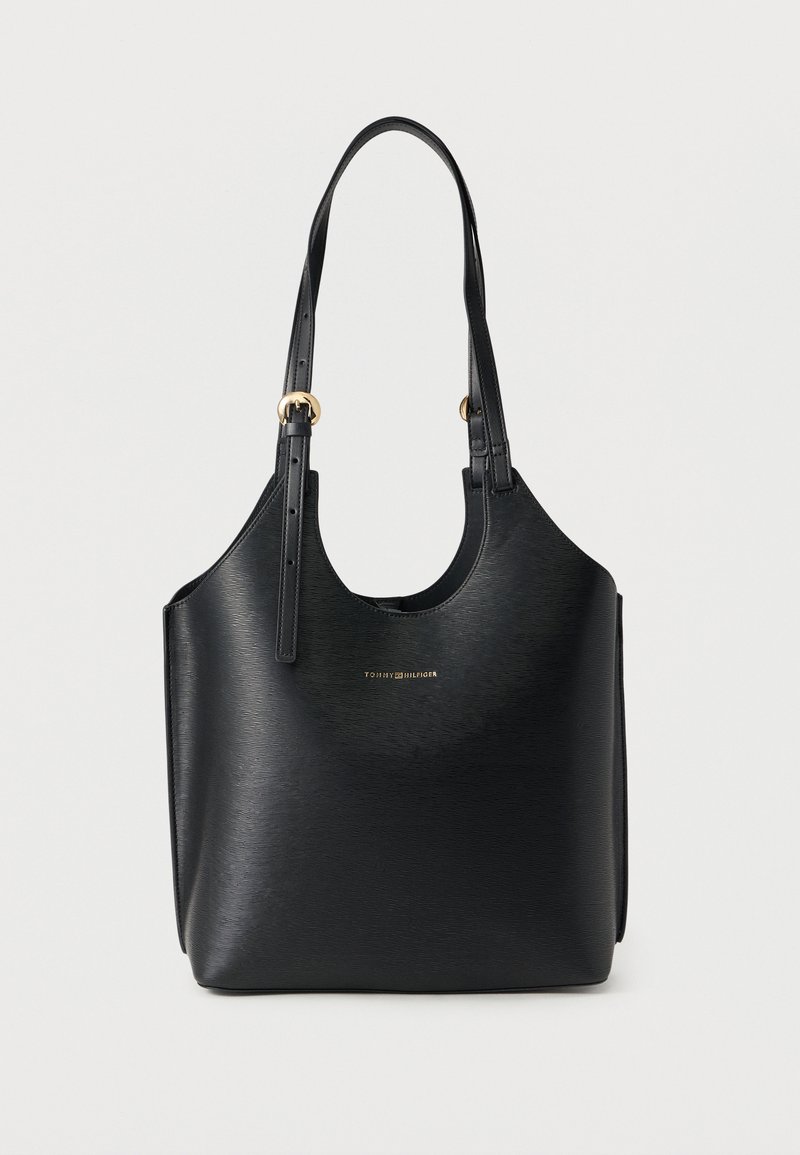 Sac à bandoulière en cuir noir texturé avec des bretelles ajustables et un petit logo doré Tommy Hilfiger sur le devant.