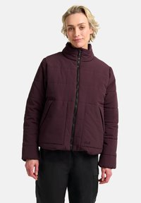 Donker bordeaux pufferjack met een hoge kraag, ritssluiting aan de voorkant, grote zakken en een quiltontwerp. Dikke, gladde textuur met branding aan de onderzoom.