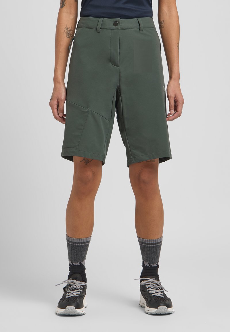 Grüne Shorts aus leichtem Material, mit geradem Schnitt, vorderen Taschen und einer Reißverschlusstasche an der Seite.