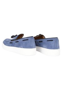 Scarpe di camoscio blu con suola in gomma bianca, caratterizzate da accenti neri e un design stile mocassino con ritagli vicino alla parte superiore.