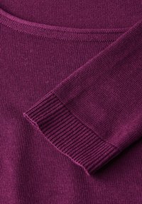 Strickpullover in tiefem Lila, mit glattem Material, Rundhalsausschnitt und gerippten Ärmelbündchen. Weicher Stoff mit leichtem Stretch.