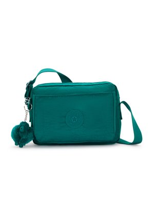 Prostokątna torebka na ramię w kolorze niebieskozielonym z zamkiem błyskawicznym, wykonana z materiału tekstylnego, z regulowanym paskiem, ozdobiona okrągłym logo i breloczkiem na pompona.