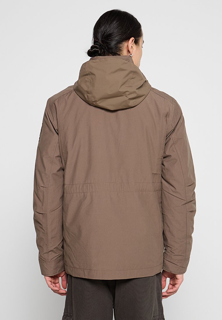 Giacca marrone isolata con cappuccio, caratterizzata da una texture liscia e un design snello. La vista posteriore mostra le cuciture e gli elementi regolabili.