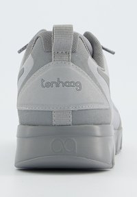 Baskets grises avec un tissu texturé et des accents lisses. Présente une poignée, un détail de logo et une semelle sculptée et rembourrée.