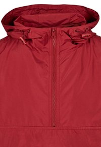 Červená lehká bunda s půlzipovým zapínáním, nastavitelnou kapucí se stahovacími šňůrkami a hladkým povrchem.