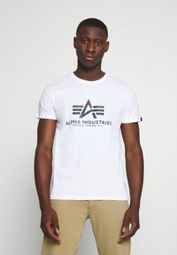 Camiseta de algodón blanca con un logo gráfico multicolor que presenta elementos geométricos en el frente, mangas cortas y cuello redondo.